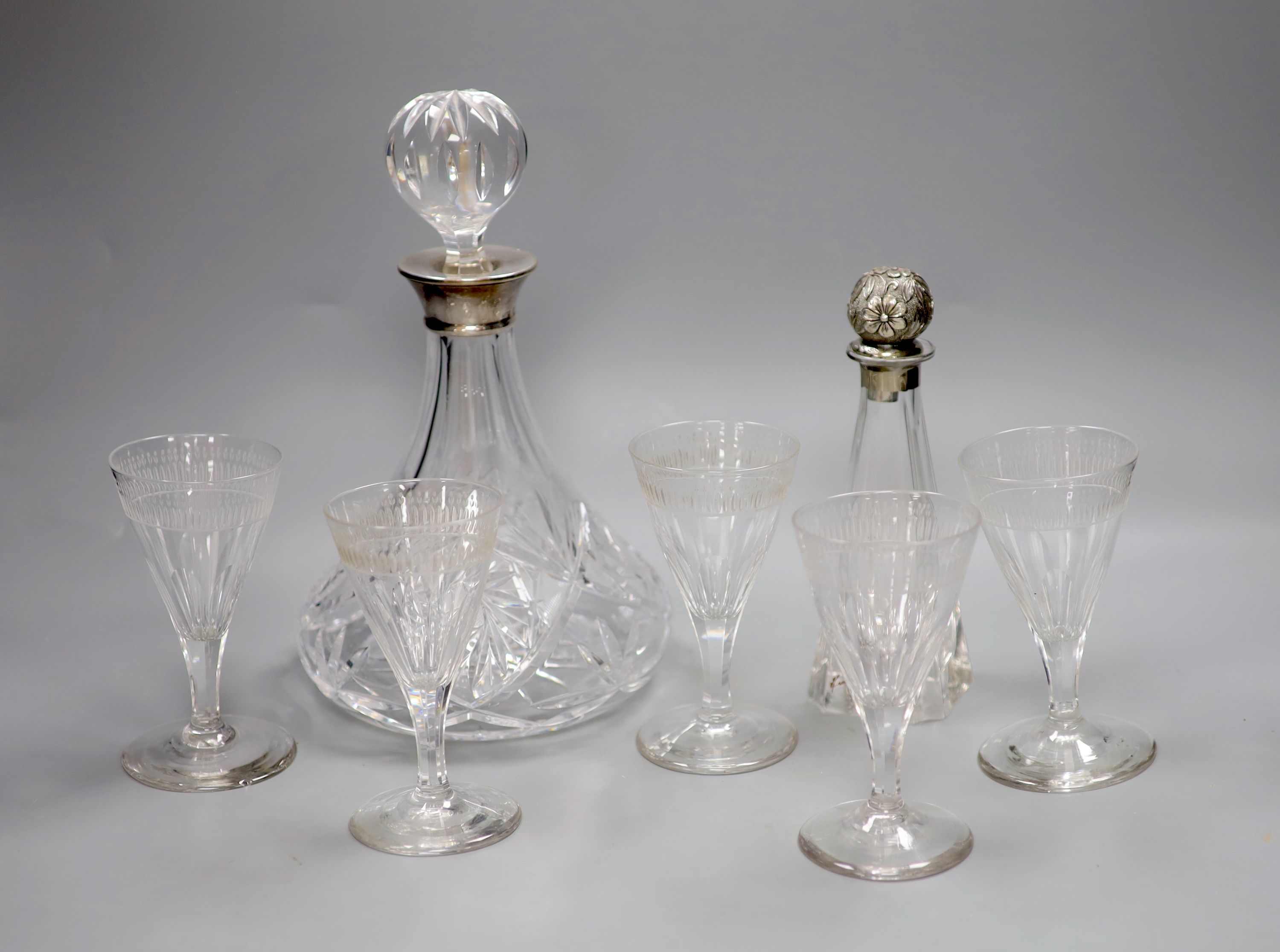 A silver collared cut glass decanter and a glass scent bottle with 800 standard silver stopper, tallest 27cm and a set of 5 etched wine glasses.